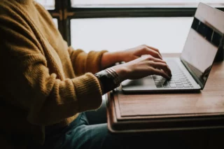 A person sitting and using a laptop.